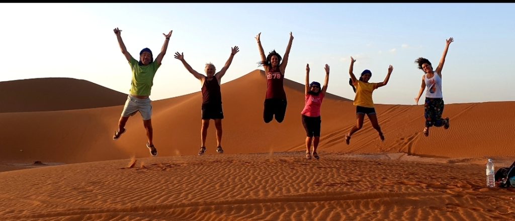 groupe heureux qui saute dans le desert